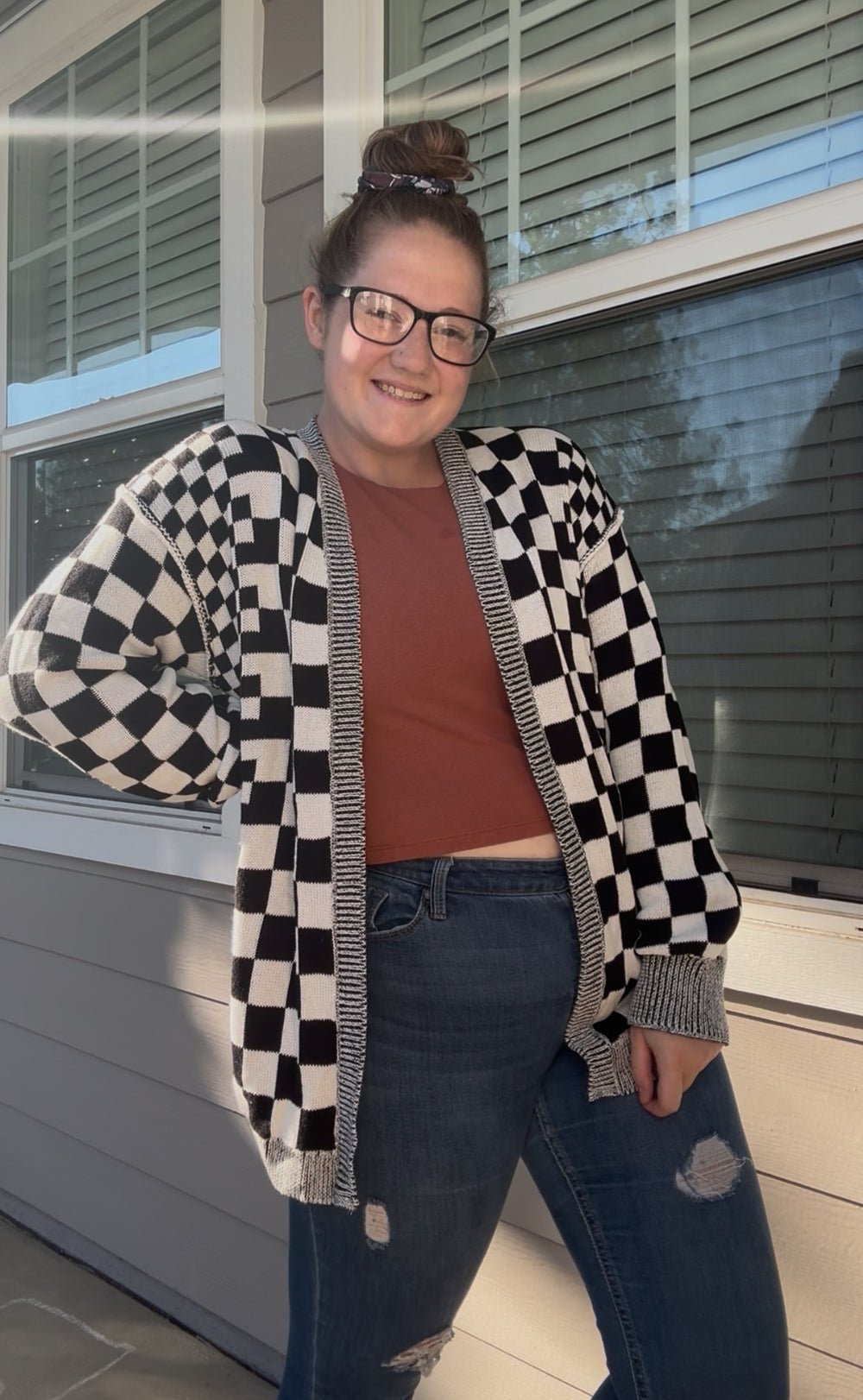 The founder of Essence of Renée wearing a black and white checkered cardigan